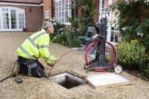 engineer inspects a blocked household drain